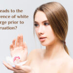 What leads to the occurrence of white discharge before menstruation?